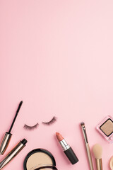 Make up concept. Top view vertical photo of false eyelashes mascara lipstick makeup brushes...