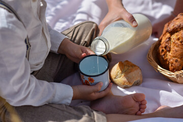 Basket of wholemeal bread. Boy in nature with milk and bread