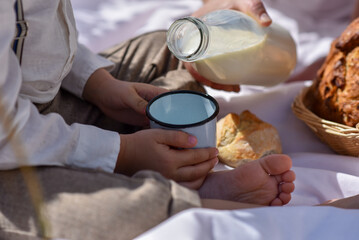 Basket of wholemeal bread. Boy in nature with milk and bread