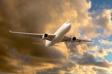 Fototapeta na wymiar Civil passenger plane in flight. Aircraft climb into the sunset sky. Airplane front view.