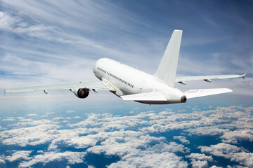 White passenger plane in flight. Aircraft fly away above the clouds. Back view of aircraft.