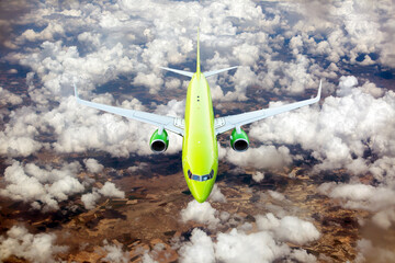 Green / lime passenger plane in flight. Aircraft  flies high above the clouds and Earth. View of...