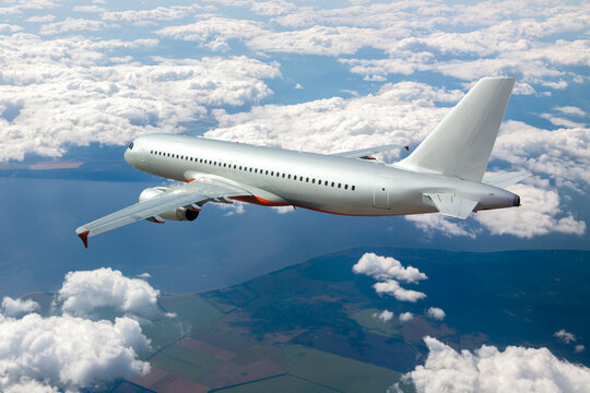 Silver passenger plane in flight. Aircraft  flies high above the clouds. Back view of aircraft.