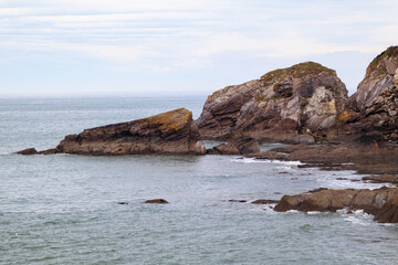 Fototapeta na wymiar Huge cliffs in the ocean. Rocky ocean coast and cloudy skies