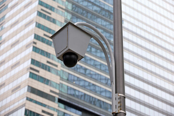 Outdoor surveillance video camera on skyscraper background. Cctv camera, concept for security, privacy and protection from crime