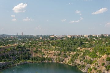 rocks of a flooded granite quarry on a background of cloudy sky