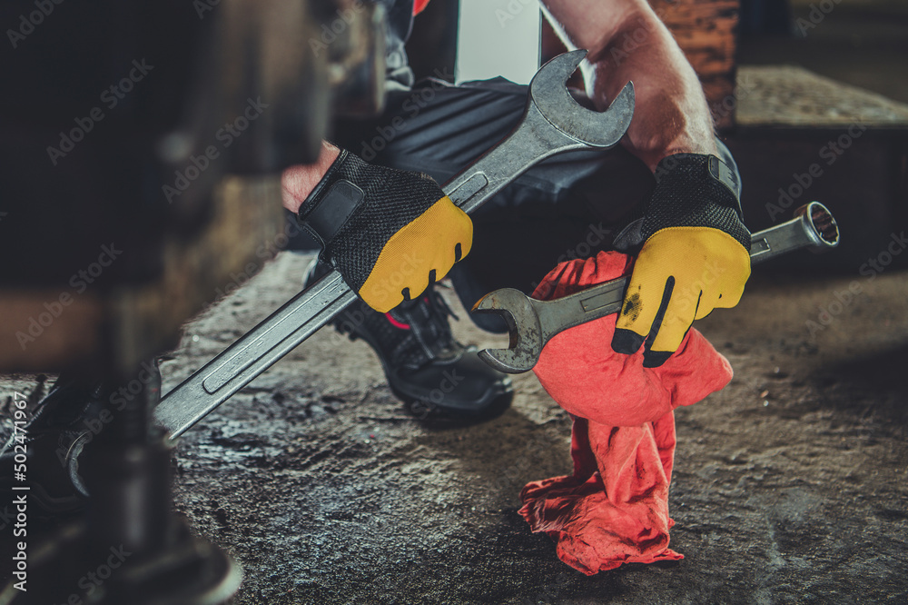 Wall mural heavy equipment mechanic with large iron wrenches