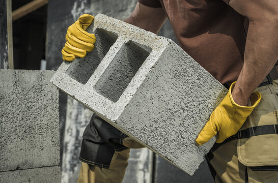 Construction Worker Moving Hollow Dense Concrete Blocks