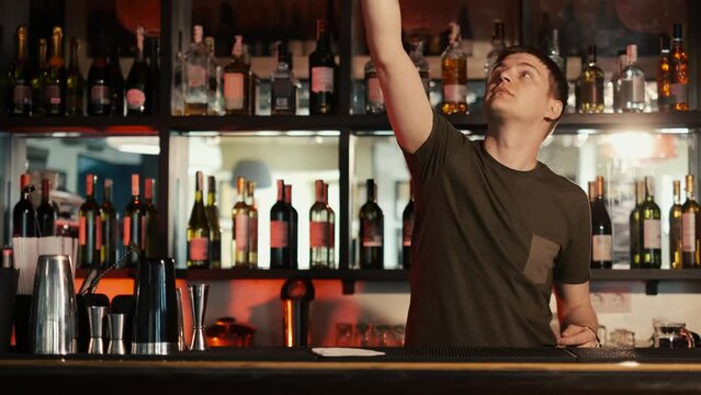 A professional bartender is preparing an alcoholic cocktail with ice cubes to customers at the bar or disco club,Sex on the beach cocktail.