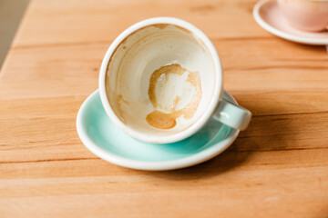 An empty cup with remnants of foam after a cappuccino. A man drank coffee in a cafe