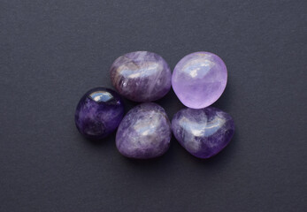 Gemstone minerals on a black background. Round tumbling minerals of amethyst and amethyst crystal.