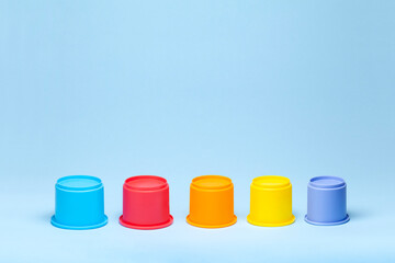 Colorful plastic cylinders on blue background