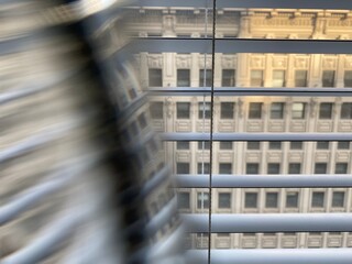 Abstract pattern created with prism in front of camera lens. Facade of a historic building seen through window with partial distortion. Focus on Venetian blinds