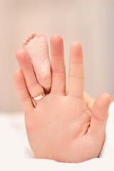 hands of father holding newborn baby feet.