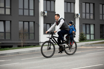 Naklejka na ściany i meble father riding bike with son in bike seat