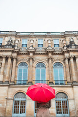 Anonymous woman with red umbrella from a rainy day in vintage place.