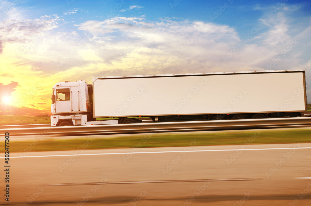 Canvas Prints side view of a truck with a trailer on a countryside road in motion against a sky with a sunset