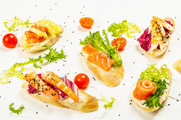 Assorted open sandwiches with salted salmon, shrimps, cream cheese, salad leaves and cherry tomatoes