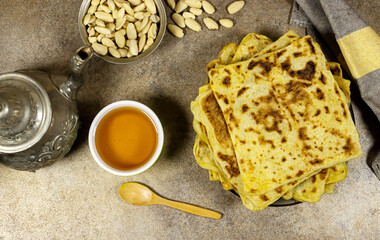 Traditional Handmade Algerian pancakes named rghaif or msemen with honey and almond and arabic teapot 