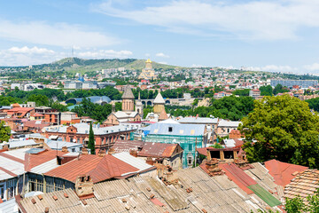Scenic aerial beautiful view panorama of old historic city Tbilisi center, architecture buildings roofs, Georgia in summer sunny day, nature bright landscape