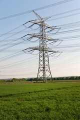 Green electricity, green energy, eco energy, eco electricity, transmission tower overhead line masts, a lot of high-voltage power line, high voltage pylons also known as power pylons on the fields