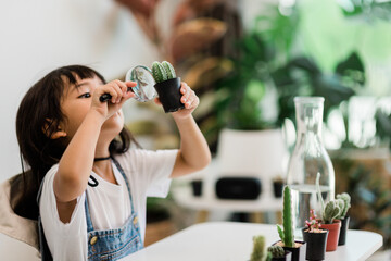 Asian little girl is planting plants in the house, concept of plant growing learning activity for a preschool kid and child education for the tree in nature