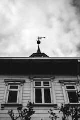 Beautiful windows and tower with compass rose in a old centuries building with neoclassical architecture and ornaments in a cloudy day, Valdivia, Chile (in black and white)