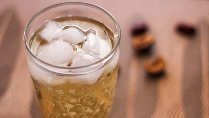 Chrysanthemum Juice, chilled, served in a clear glass placed on a black table