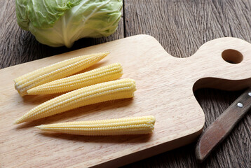 Fototapeta na wymiar Delicious baby corn, fresh young baby corn on a wooden cutting board on the table.