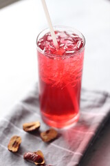 roselle juice in a glass, placed on a white table.