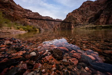 Fototapeta na wymiar Submerged Rocks in the Colorado River with the Black Bridge