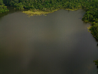 Aerial drone view of a dam lake with tropical trees in Mount Ledang National Park, Johor, Malaysia.