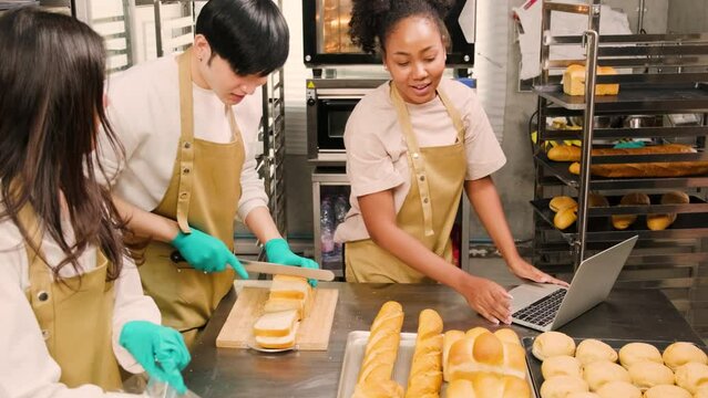 Three young friends and startup partners of bread dough and pastry foods busy with homemade baking jobs while cooking orders online, packing, and delivering on bakery shop, small business entrepreneur