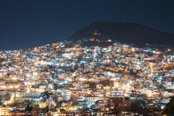 Lights of the night city on the slope of the mountain. The light of lanterns and windows of houses...