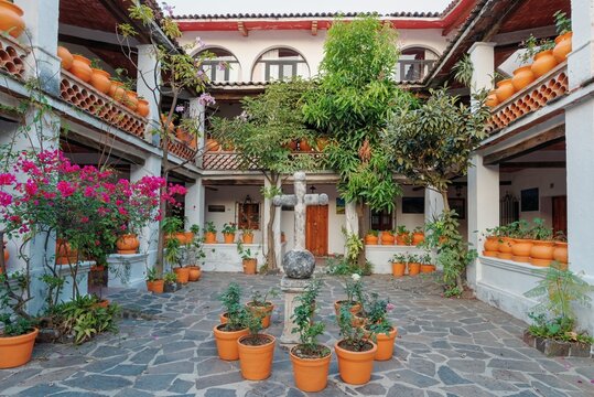 Colonial style patio. Large flower pots, cross, columns. Taxco city in Mexico