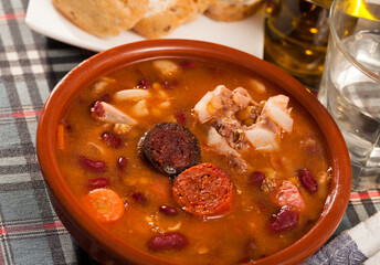 Traditional Asturian rich beans stew with pork shoulder, morcilla and chorizo (Fabada) served in...