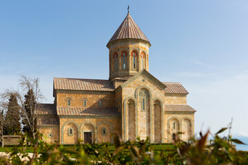 Fototapeta na wymiar Picturesque sunny spring landscape with Church of Saint Nino in Georgian Orthodox monastic complex at Bodbe near Sighnaghi town