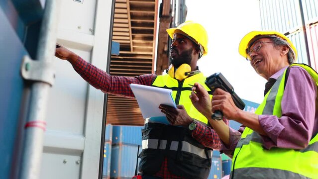 Old man warehouse worker and black male dock worker use barcode scanner at warehouse container yard