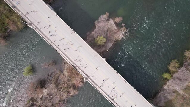 people running on bridge over river