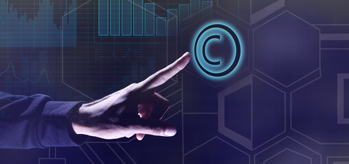 Hand of businessman touching symbol of copyright on dark blue background