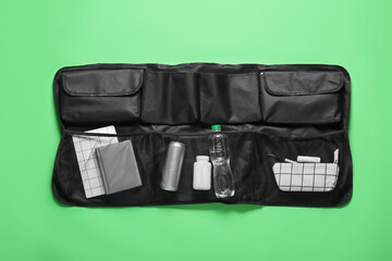 Fototapeta Travel organizer with stationery, bottles of drink and pills on green background obraz