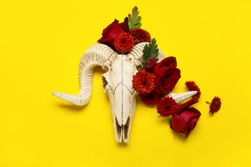 Skull of sheep with flowers on yellow background