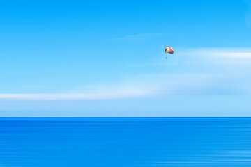 Parachutist at sea in a minimalist photo.