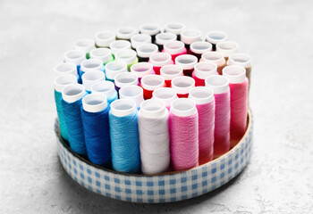Holder with sewing threads on light background