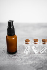 natural beauty and organic ingredients in skincare, amber skincare bottle with small bottles of ingredients next to it