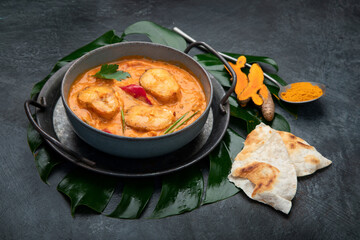 Kerala fish curry on dark background.