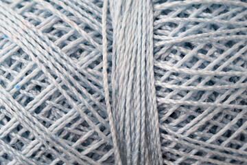 Macro texture of cotton blue thread, close-up, copy space. Macro Photography of a coil with threads. Sewing background, screensaver. Abstraction, interweaving of natural threads