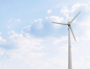 Fototapeta premium Wind turbine generator against bright sky. Wind power to generate electricity. Low carbon power to limiting climate change. The renewable and clean energy source for the sustainable development.