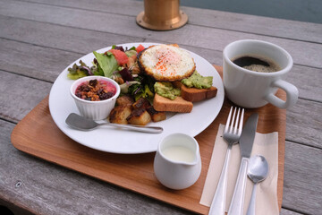 目玉焼きとアボカドディップを乗せたトーストとサラダ、彩り豊かな健康的な朝食とコーヒー
