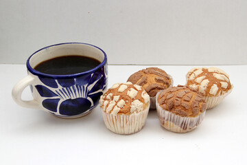 Fresh, delicious and fluffy Mexican bread Manteconchas cupake type vanilla and chocolate flavor accompanied by coffee on a white background traditional of the culture of Mexico
